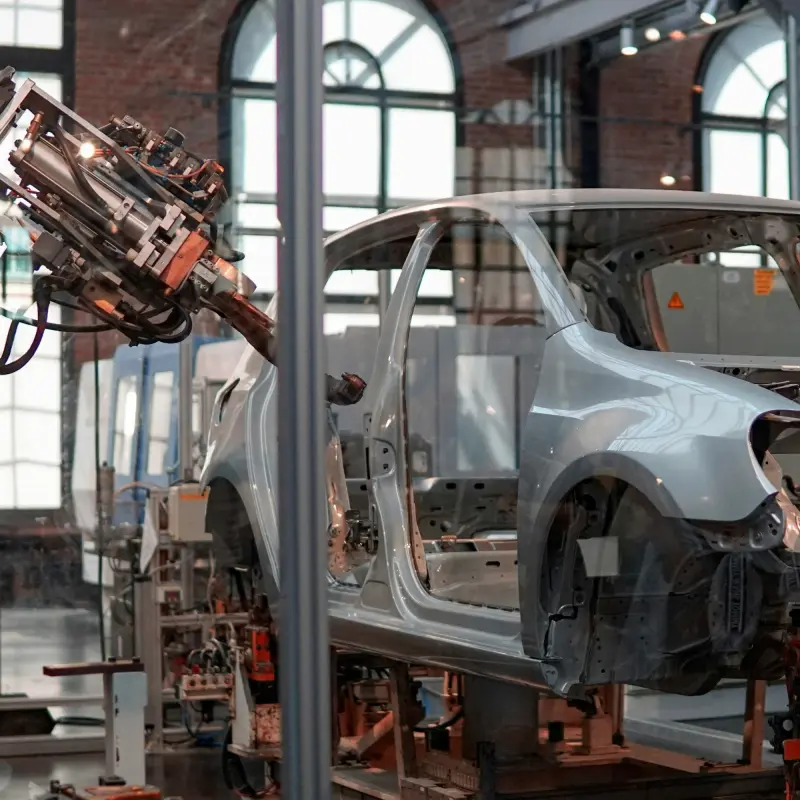 Car body on a production line next to a robot arm